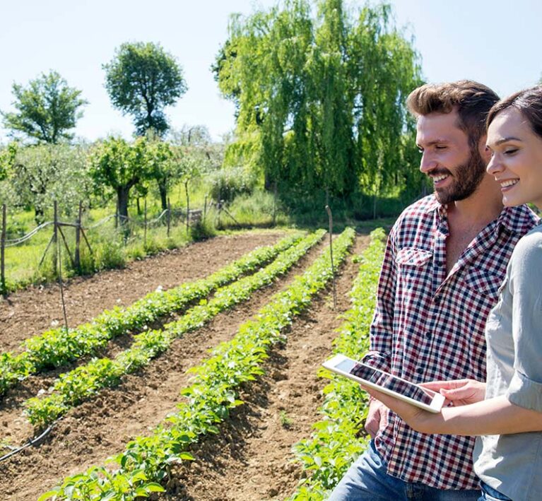 young-couple-standing-in-vegetable-garden-holding-2025-04-04-16-55-23-utc